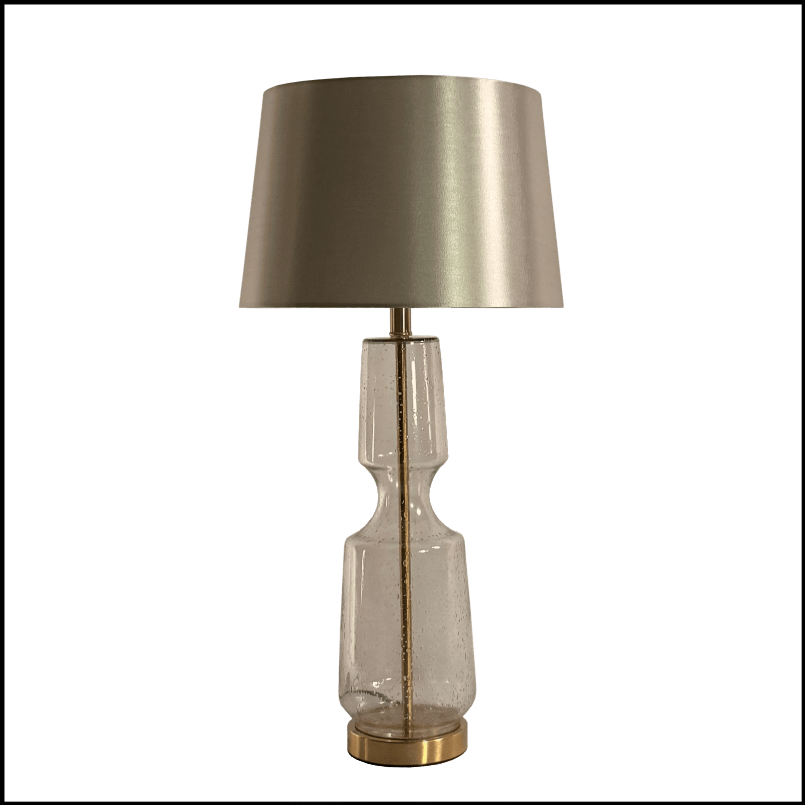 O Abajur Silverglass da Lampadaria é uma peça de design clássico moderno que combina a transparência e o brilho de forma harmoniosa. Sua base alta em vidro artesanal transparente na cor prata, moldada no formato de balaústre, confere leveza e elegância ao ambiente, enquanto os detalhes em metal bronze complementam com sofisticação. A cúpula translucida em tecido algodão mercerizado na cor prata brilhante distribui a luz para cima e para baixo criando uma atmosfera convidativa para leitura, ilumina lateralmente com luz difusa e contribui com a iluminação geral do ambiente.