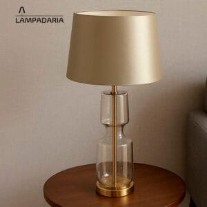 Abajur transparente com detalhes em bronze e cúpula prateada brilhante