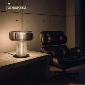 Abajur moderno de vidro em um ambiente moderno com paredes de concreto em cima de uma mesa lateral de concreto